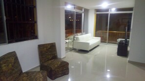 Relax in a stylish living area with a sofa, armchairs, and a large window offering scenic views.