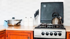 A kitchen with a Westpoint stove, a kettle, a pot, and two labeled containers.