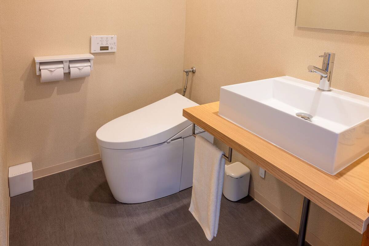 A small bathroom with a toilet, a sink, and a towel rack.