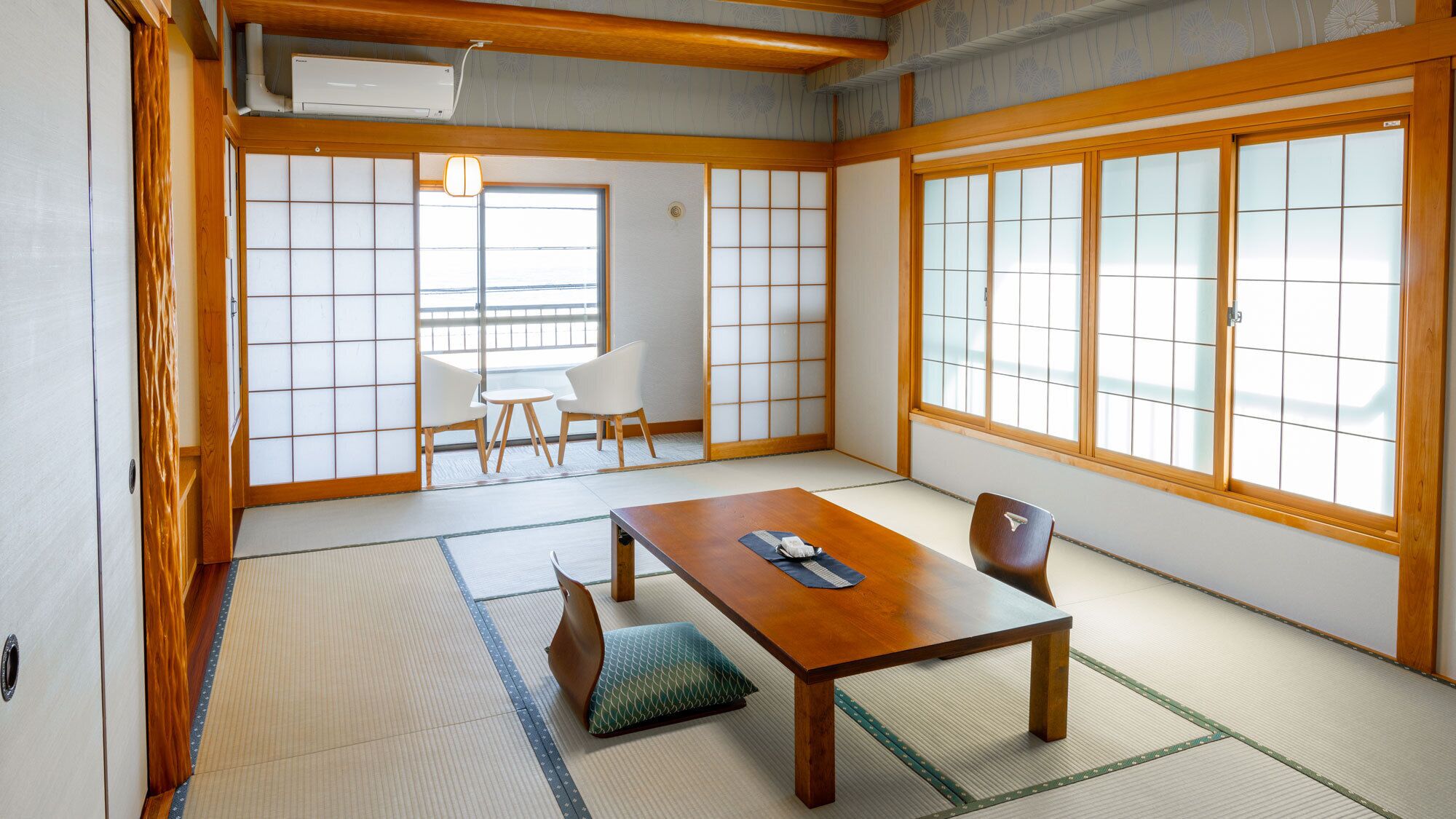 Una habitació japonesa tradicional amb tatami, una taula baixa i portes corredisses.