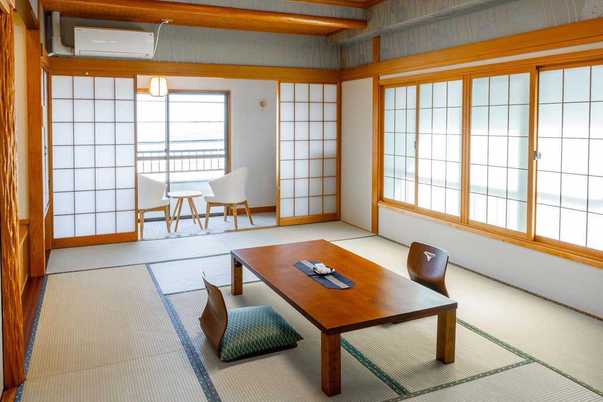 Una habitació japonesa tradicional amb tatami, una taula baixa i portes corredisses.
