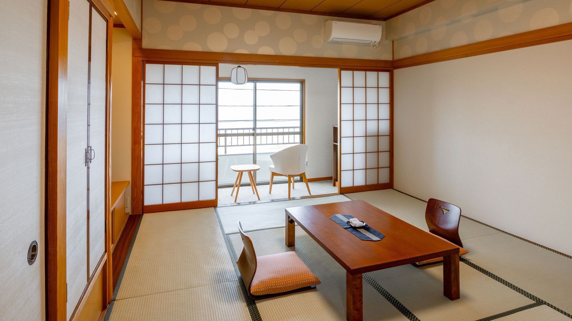 Una habitació japonesa tradicional amb tatami, una taula de fusta i portes corredisses.