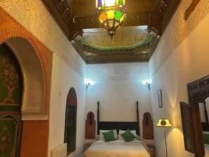 A room with a large bed, ornate ceiling, and detailed wall designs. - 19th century traditional Riad located in the heart of the medina (Marrakech)