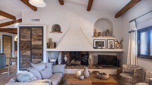 A cozy living room with a fireplace, a sofa, a coffee table, and a TV. - Sheepfold, 4 bedrooms, 10 people, heated pool (Bonifacio)