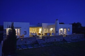 Stylish, two-story building with a minimalist design and a rustic stone wall.