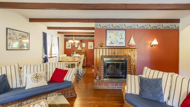 A cozy living room with striped sofas, a fireplace, and a dining area. - Pet Friendly 3 Bedroom 5 Minutes to Town. (Cape May)