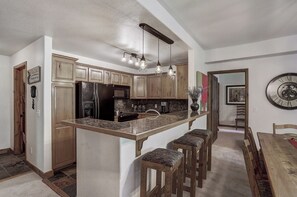 Enjoy cooking in this well-equipped kitchen with a central island, bar stools, and modern appliances.