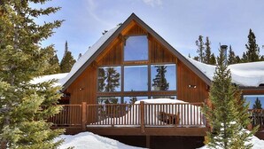 A wooden cabin with large windows, a deck, and a snowy landscape. - Breck Cabin, Ten Mile Range Views, Wrap Deck, Fireplaces, Sleeps 6 (Breckenridge)