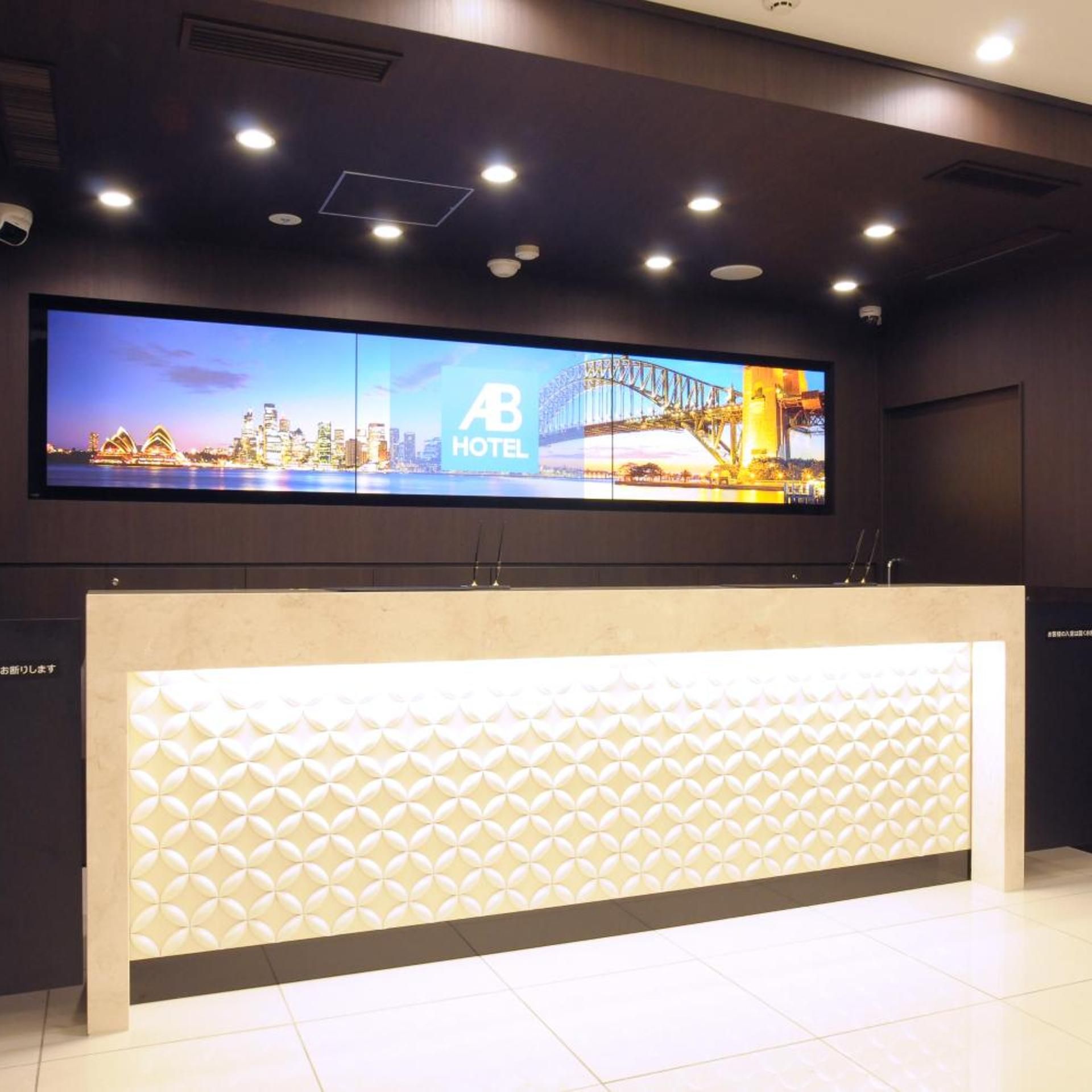 A hotel reception desk with a digital display above it.