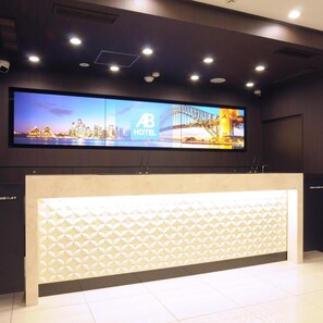 A hotel reception desk with a digital display above it. - Ab Hotel Omihachiman (Omihachiman)