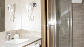 Een moderne badkamer met een douchecabine van glas, een wastafelmeubel en een handdoekrek.