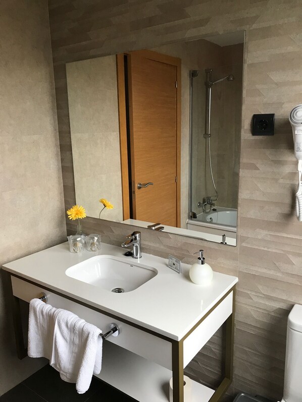 A modern bathroom with a white sink, a mirror, and a shower. - Hotel Mercedes (Camargo)