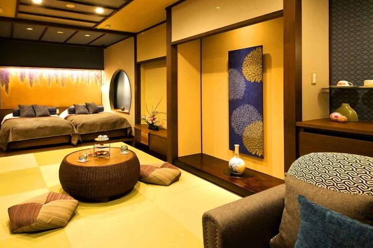 A traditional Japanese-style room with tatami flooring, a low table, and a sofa.