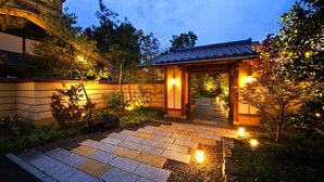 A traditional Japanese-style garden with a stone pathway leading to a wooden torii gate. - Kanazawa Yuwaku Onsen Hyakurakuso (Kanazawa)