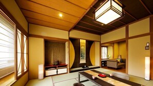 A traditional Japanese room with tatami flooring, a low table, cushions, and sliding doors. - Kanazawa Yuwaku Onsen Hyakurakuso (Kanazawa)