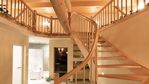 A spiral staircase with wooden railings and a wooden ceiling. - Albergo Croce Bianca (Poschiavo)