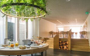 Un café moderno con mostrador de madera, una máquina de café y diversas opciones para el desayuno.