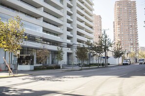 Un edificio moderno de varios pisos, con amplios ventanales y un acceso cubierto.