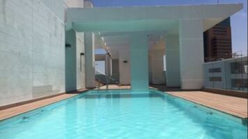 Swim laps in a clean, contemporary pool surrounded by a wooden deck and white walls.