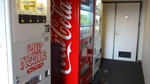 Zona de máquinas expendedoras con una máquina de Coca-Cola y una máquina de Cup Noodles.