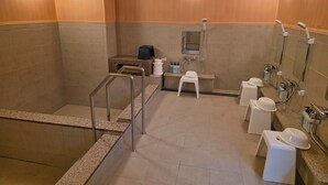 Une salle de bain moderne équipée d’une douche, de toilettes et d’un lavabo, avec des murs en bois et un comptoir en granit.