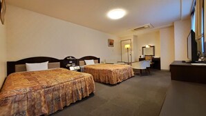Une chambre d’hôtel avec deux lits, un bureau, une chaise, une lampe de bureau, un miroir et un téléviseur.