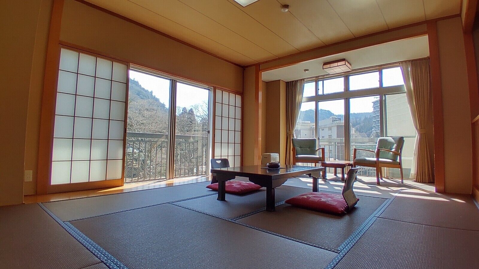 Un espacio tradicional con esteras de tatami, puertas correderas, una mesa baja y asientos.