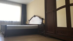 A bedroom with a bed, a nightstand, and a wardrobe. - Appartments in the city center (Kyiv)