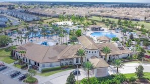 A resort with multiple buildings, a central pool, and surrounding palm trees. - Stay at this nice, spacious & stylish 4 bedroom townhouse with pool, near Disney (Davenport)