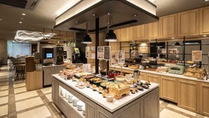 A modern kitchen with a central island, wooden cabinets, and a dining area with tables. - Super Hotel Premier Tokyo Station Yaesu Chuo (Tokyo)
