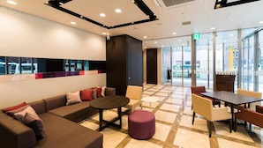 A modern lobby with a seating area, a reception desk, and a glass wall offering a view of the outside. - Super Hotel Premier Tokyo Station Yaesu Chuo (Tokyo)