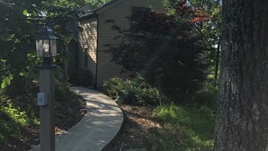 Ein Weg zu einem Haus, umgeben von Bäumen und Grün.