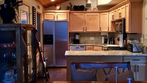 Eine moderne Küche mit Holzausbau, Edelstahlgeräten und einer zentralen Kochinsel.