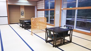 A traditional Japanese room with tatami mat flooring, shoji screens, and a tatami mat-covered table with chairs. - Shiozawa Onsen Shichihokan (Takayama)
