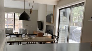 A kitchen with a large island, white cabinetry, and a sliding glass door leading to a deck. - NEXT TO GLAZE MEADOW, CUTE, WITH MANY AMENITIES! (Sisters)