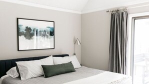 A bedroom with a bed, a bedside lamp, a window with curtains, and a framed picture on the wall. - NEXT TO GLAZE MEADOW, CUTE, WITH MANY AMENITIES! (Sisters)