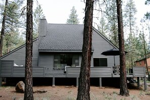 A cabin with a sloped roof, large windows, and a deck area. - NEXT TO GLAZE MEADOW, CUTE, WITH MANY AMENITIES! (Sisters)