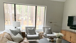 A modern living room with a leather sofa, two armchairs, a coffee table, and a TV mounted on the wall. - NEXT TO GLAZE MEADOW, CUTE, WITH MANY AMENITIES! (Sisters)