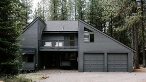 A two-story house with a balcony, a garage, and a covered entryway. - NEXT TO GLAZE MEADOW, CUTE, WITH MANY AMENITIES! (Sisters)