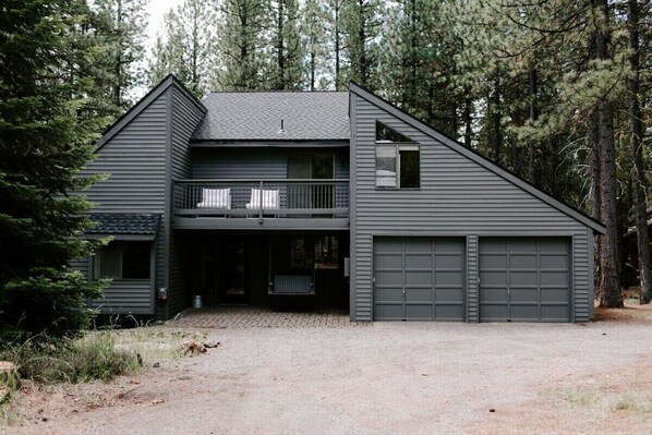 A two-story house with a balcony, a garage, and a covered entryway. - NEXT TO GLAZE MEADOW, CUTE, WITH MANY AMENITIES! (Sisters)