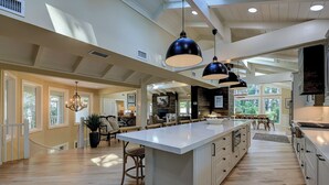 A spacious kitchen with a large island, pendant lighting, and a view of the outdoors. - 12 Royal Tern - 2nd Row (70 yard walk) to the Ocean and Large Private Pool (Hilton Head Island)