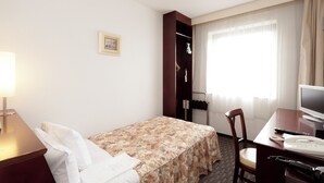 A hotel room with a bed, a desk with a computer, a chair, a lamp, a wardrobe, and a window with curtains. - Hotel Fukushima Green Palace (Fukushima)