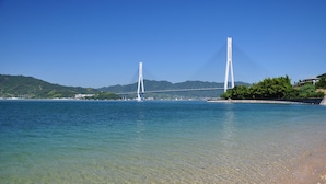 Un puente sobre un cuerpo de agua, con cielos despejados y montañas a lo lejos.