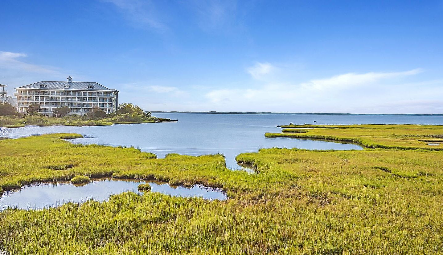 A coastal hotel with a large building and a view of the sea.