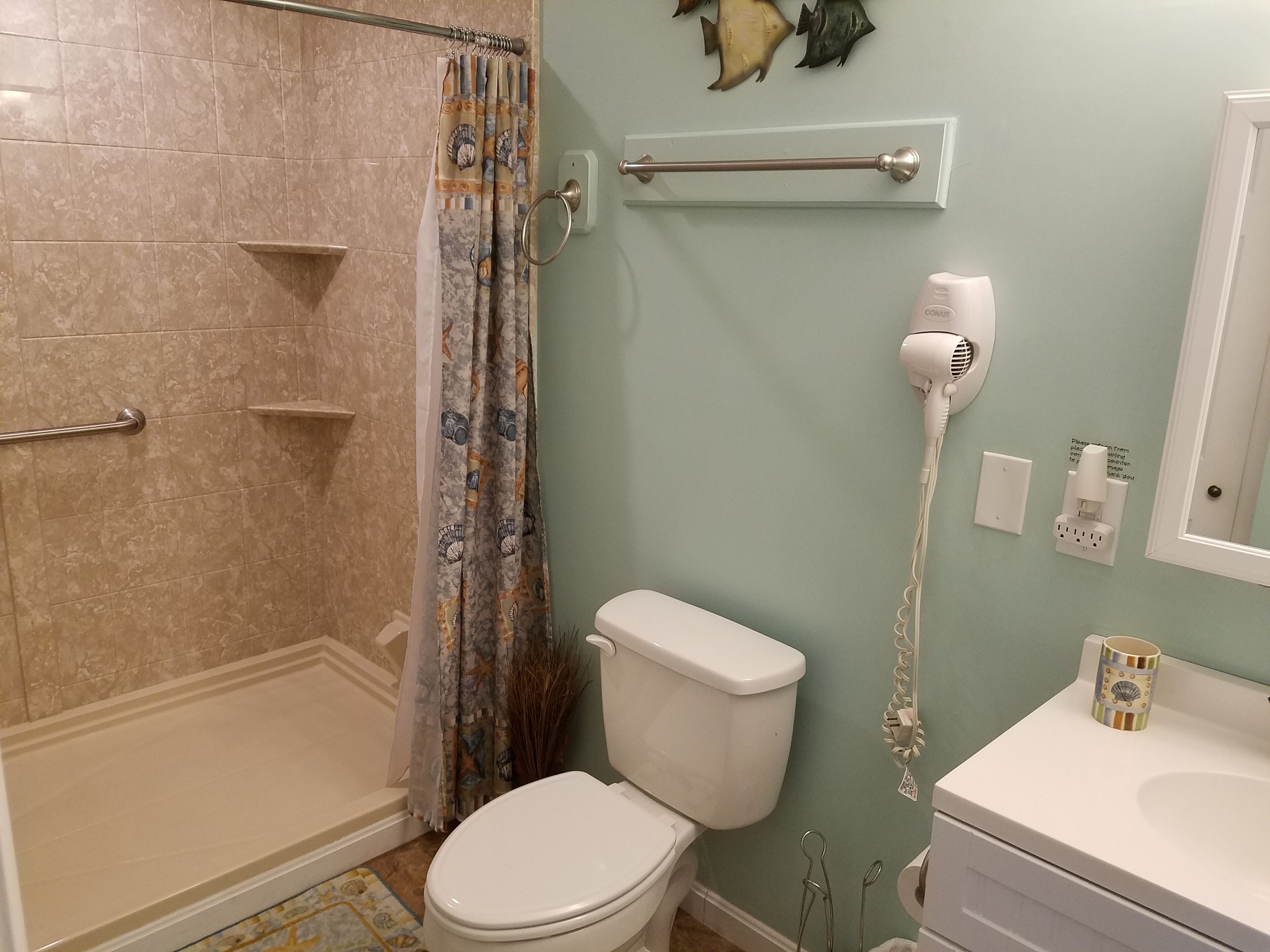 Un baño con ducha, inodoro y lavabo.