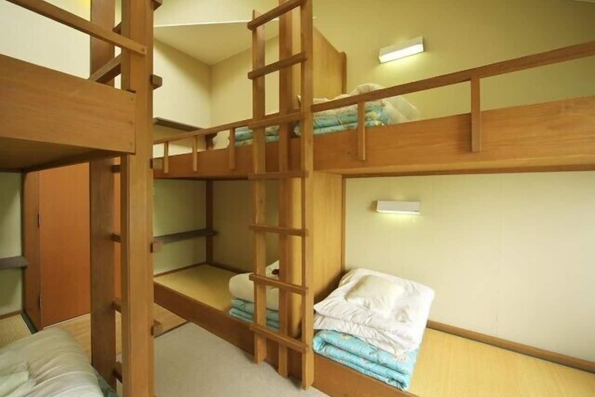 Habitación con literas, una pequeña repisa y una luz instalada en la pared.