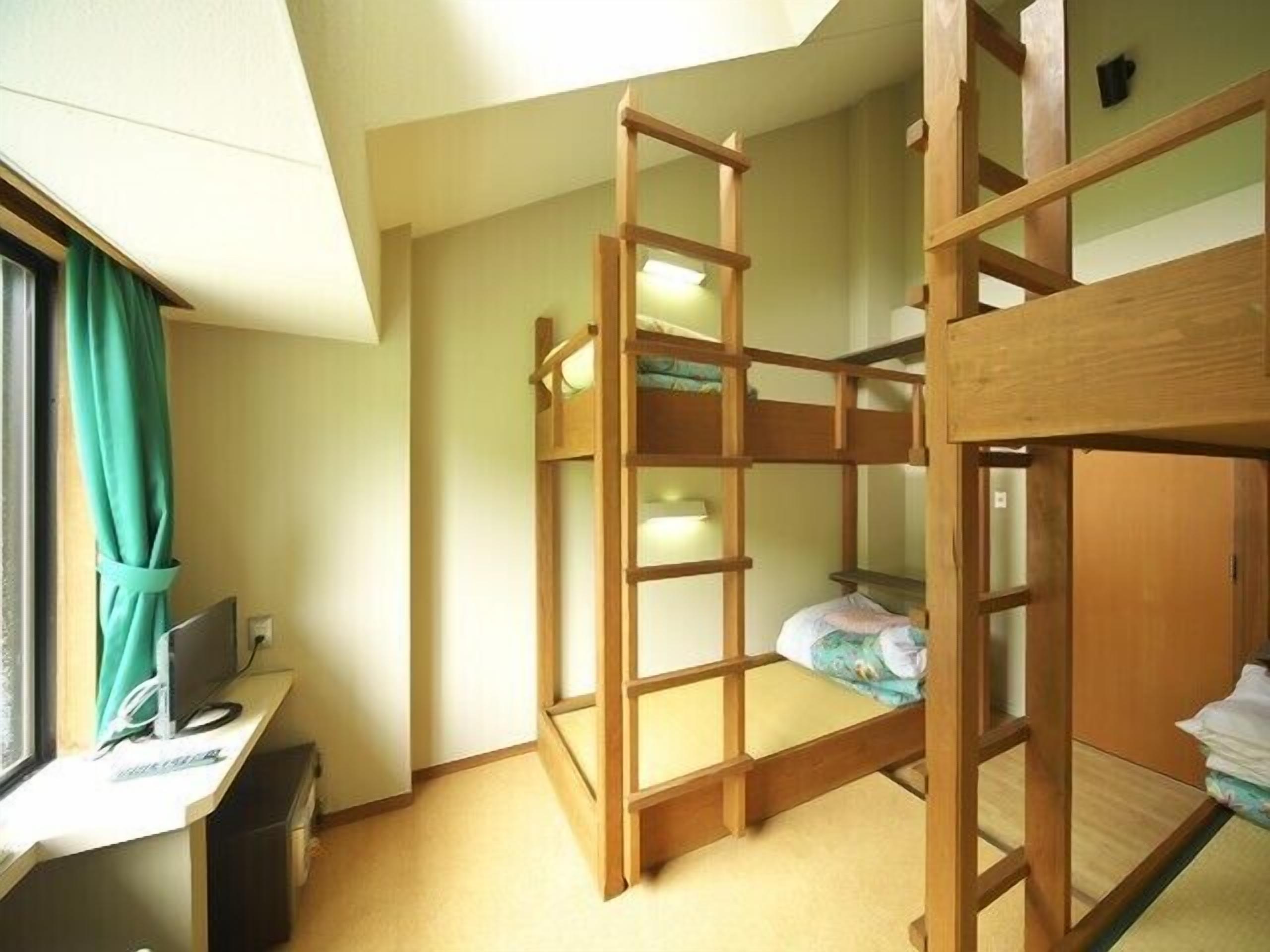 A bunk bed room with a desk and a computer.