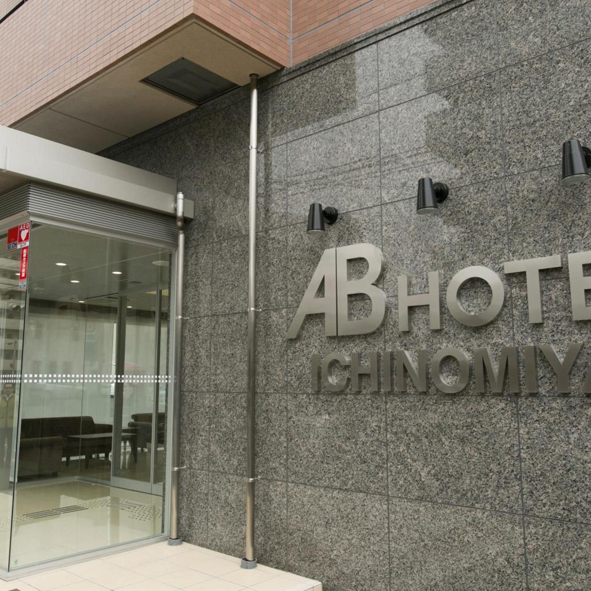 A hotel entrance with a glass door and a sign that reads 'ABHOTEL CHINOMIYA'.