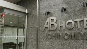 A hotel entrance with a glass door and a sign that reads 'ABHOTEL CHINOMIYA'.