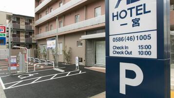Señal de hotel con un símbolo de estacionamiento, que indica una zona de estacionamiento.